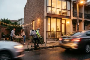 Courier delivering package to a modern Sydney terrace at night