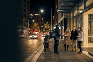 Courier delivering packages to smiling customers at night in Sydney